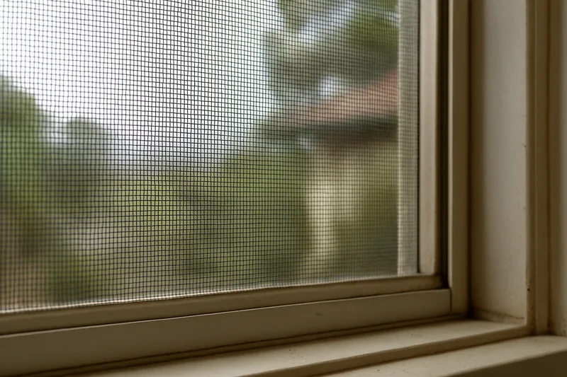 A fine metal mesh screen fixed over an openable window — bushfire screens and mesh, Adelaide Hills. Illustrative example.